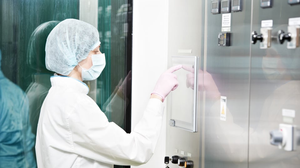 Female pharmaceutical employee operating the production line